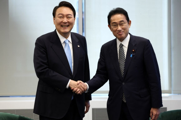 윤석열 대통령이 21일(현지시간) 미국 뉴욕의 한 컨퍼런스 빌딩 안에서 기시다 후미오 일본 총리와 한일정상 약식회담을 갖기 전 반갑게 손을 맞잡고 있다. 2022.9.22 대통령실 제공