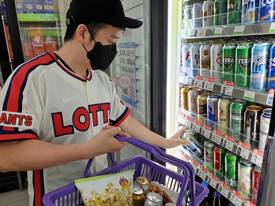 A customer picks up a beer can at a CU convenience store. [CU]