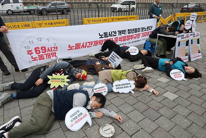 9일 오전 서울 용산구 전쟁기념관 앞에서 열린 ‘노동시간 개악 저지 윤석열 정부 규탄 기자회견’에 참석한 전국민주노동조합총연맹 소속 청년 노동자 등이 ‘퍼포먼스’를 하고 있다. 연합뉴스