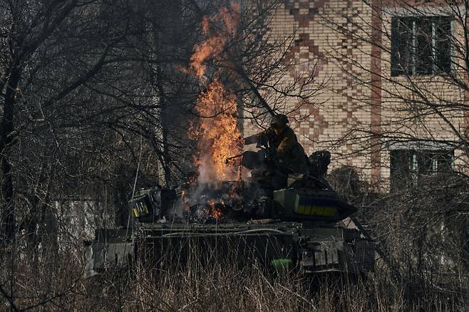 지난 6일(현지시간) 우크라이나 도네츠크주 차시우 야르에서 우크라이나 군인이 전차에 붙은 불을 끄고 있다.(AP/뉴시스)