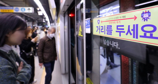 지난 9일 서울의 한 지하철역 승강장에 사회적 거리두기 안내문구가 표시돼 있다. 뉴시스