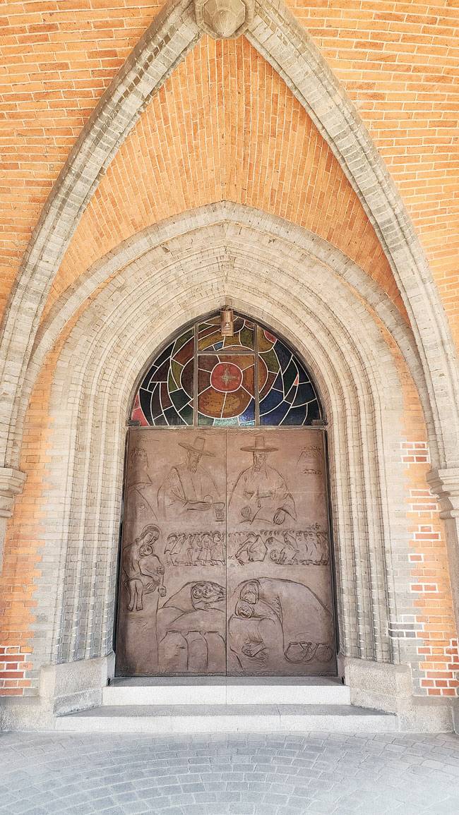 중앙문의 청동 부조는 한국 교회 초창기 모습을 담고 있다. 최의순 조각가의 작품.