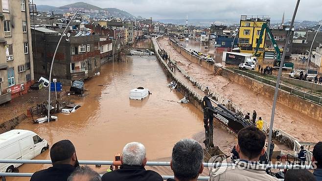 튀르키예 동남부 지역 홍수 (산리우르파[튀르키예] AFP=연합뉴스) 15일(현지시간) 튀르키예 동남부 산리우르파와 아디야만 지역에 폭우로 인한 홍수가 발생해 최소 10명이 숨졌다. 주민들이 홍수에 휩쓸린 시내를 바라보고 있다. 2023.3.15 photo@yna.co.kr