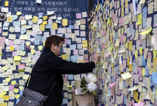 지난 2001년 일본 아카시시 불꽃축제 과정에서 발생한 육교 압사 참사의 유가족 시모무라 세이지 씨가 17일 오전 서울 이태원 참사 현장에서 추모 메시지를 붙이고 있다. 사진=연합뉴스