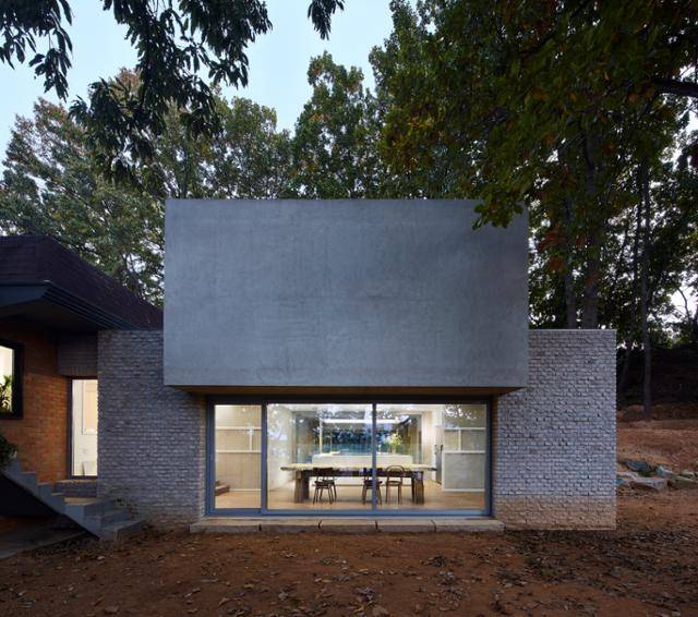 집에 생기를 불어넣는 신축 건물. 주택에 구현한 고인돌이라고 할까. 고벽돌 기둥이 거대한 노출 콘크리트 덩어리를 받치는 형태로 건축가의 실험정신이 돋보인다. 김용관 건축사진작가 제공