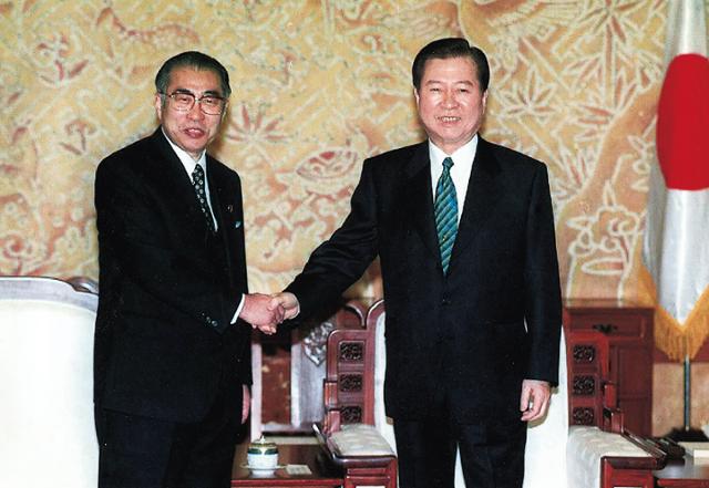 1999년 3월 20일 김대중(오른쪽) 대통령과 오부치 게이조 일본 총리가 청와대에서 정상회담을 하기 앞서 손을 맞잡고 있다. 한국일보 자료사진
