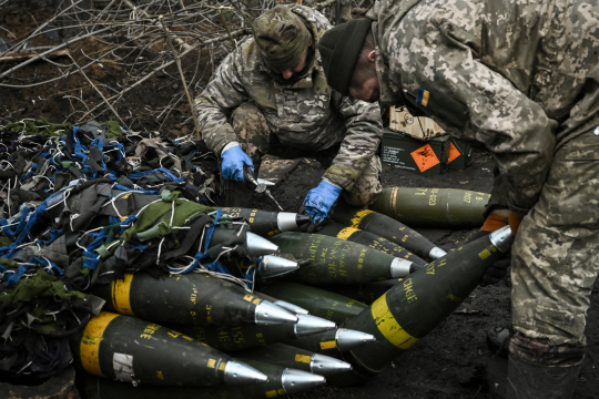 지난 11일(현지시간) 우크라이나 동부 바흐무트 인근의 한 전선에서 우크라이나 병사들이 러시아 진영을 향해 날릴 155mm M777 곡사포탄을 준비하고 있다. AFP·연합뉴스