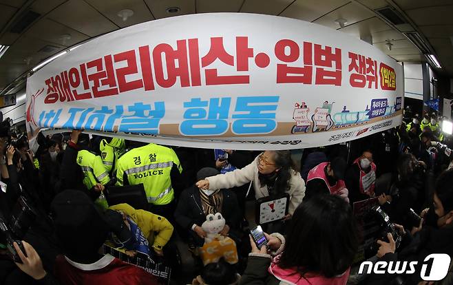 전국장애인차별철폐연대(전장연) 회원들이 2일 오전 서울 삼각지역에서 장애인 권리 예산 확보를 위한 지하철 타기 선전전에 나섰으나 승차를 저지당하고 있다.  2023.1.2/뉴스1 ⓒ News1 이동해 기자