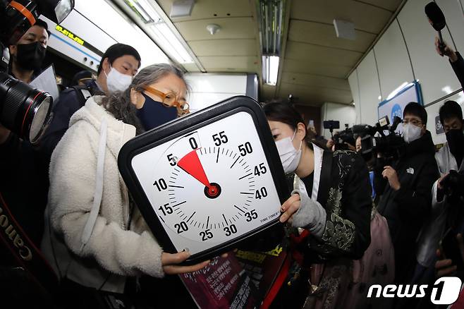 전국장애인차별철폐연대(전장연) 회원들이 2일 오전 서울 삼각지역에서 장애인 권리 예산 확보를 위한 지하철 타기 선전전에 앞서 법원의 조정안을 수용한 5분 타이머를 맞추고 있다. 2023.1.2/뉴스1 ⓒ News1 이동해 기자