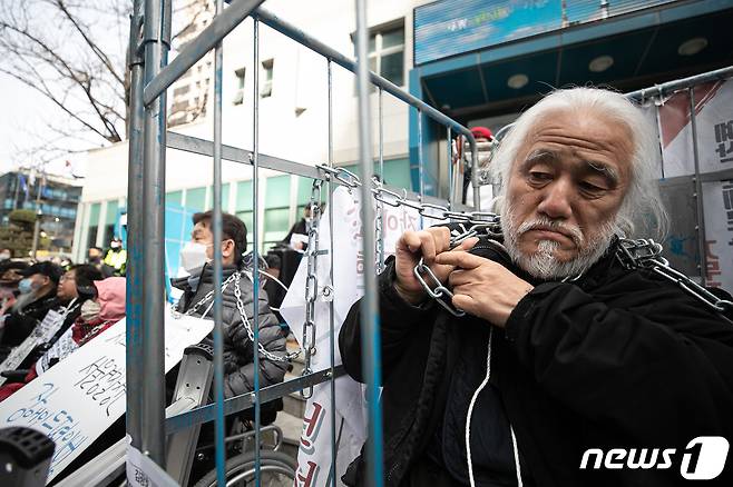 박경석 전국장애인차별철폐연대(전장연) 대표가 17일 오전 서울 종로구 서울지방경찰청 앞에서 법원의 체포영장 발부에 따른 입장발표 기자회견을 하기 전 목에 두른 쇠사슬을 만지고 있다.  2023.3.17/뉴스1 ⓒ News1 이승배 기자