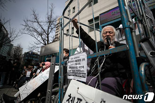 박경석 전국장애인차별철폐연대(전장연) 대표가 17일 오전 서울 종로구 서울지방경찰청 앞에서 몸에 쇠사슬을 두르고 철창 속에서 법원의 체포영장 발부에 따른 입장발표 기자회견을 하고 있다.  2023.3.17/뉴스1 ⓒ News1 이승배 기자