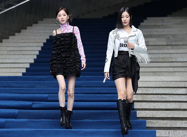 Sohee (right) and Yukyung of group Alice walks down the stairs at 2023 Seoul Fashion Show held at Dongdaemun Design Plaza in Jung-gu, Seoul, Friday. (Yonhap)