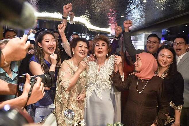 배우 양자경의 어머니 자넷 여(가운데)가 13일 말레이시아 쿠알라룸푸르에서 딸의 아카데미 여우주연상 수상 소식을 듣고 기뻐하고 있다. 쿠알라룸푸르=AP연합뉴스