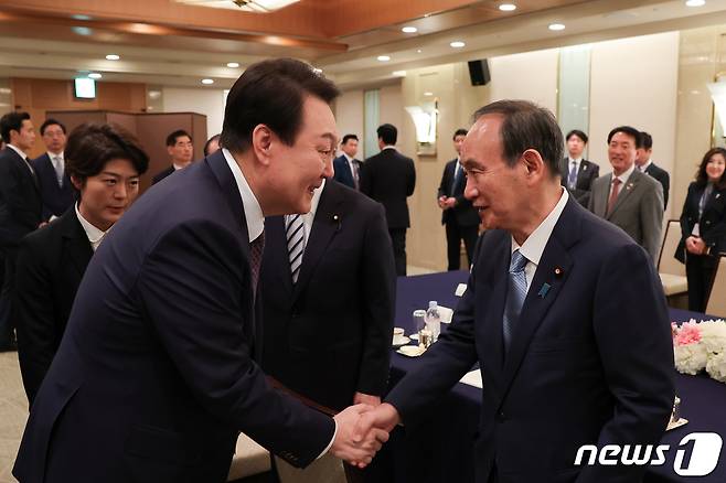 윤석열 대통령이 17일 도쿄 시내 한 호텔에서 열린 일한의원연맹 및 일한친선협회중앙회 접견에서 스가 요시히데 전 총리와 악수하고 있다. (대통령실 제공) 2023.3.19/뉴스1 ⓒ News1 안은나 기자