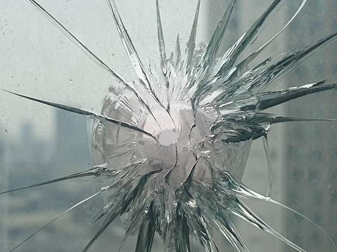 쇠구슬로 깨진 아파트 유리 창문.