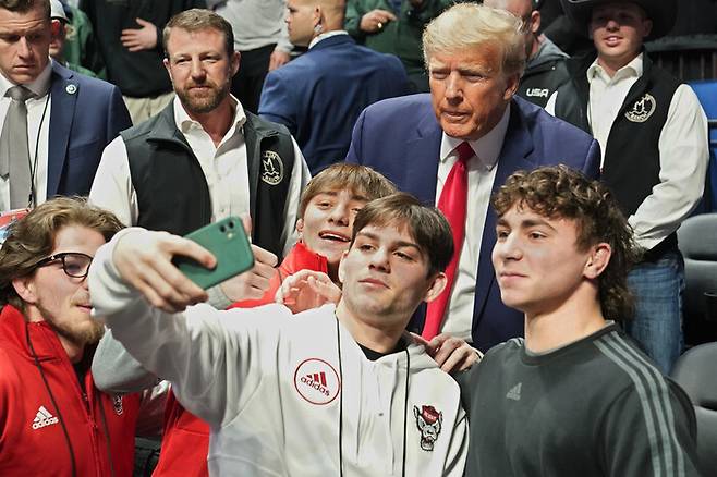 도널드 트럼프 전 미국 대통령이 18일 오클라호마주 털사에서 열린 프로레슬링 경기에 참석해 청소년들과 ‘셀카’를 찍고 있다. 털사/AP 연합뉴스