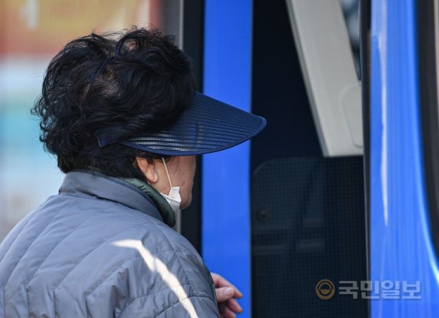 19일 서울역버스종합환승센터에서 한 시민이 마스크를 턱에 걸친 채 버스에 탑승하고 있다.