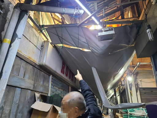 19일 오전 10시께 인천 동구 송현자유시장에서 한 상인이 천장 붕괴를 예방하고자 설치한 합판을 가리키고 있다. 최종일기자