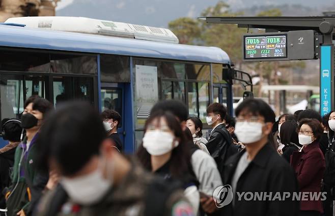 20일부터 대중교통 '노 마스크' (서울=연합뉴스) 신준희 기자 = 15일 오전 서울시내 한 버스정류장에서 마스크를 쓴 출근길 시민들이 버스를 기다리고 있다. 오는 20일부터 버스와 전철 등 대중교통에서도 실내 마스크 착용 의무가 해제되고 자율로 전환된다. 2023.3.15 hama@yna.co.kr