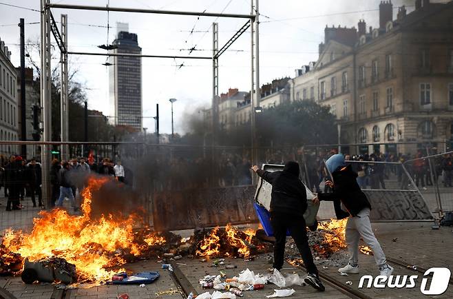 18일(현지시간) 프랑스 서부 낭트에서 시민들이 에마뉘엘 마크롱 대통령이 의회 표결없이 연금개혁 법안을 강행처리한 데 대해 항의하며 바리케이드를 쌓고 쓰레기에 불을 지르며 경찰과 대치하고 있다. 2023.03.18. ⓒ 로이터=뉴스1 ⓒ News1 김성식 기자