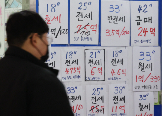지난 2월 한 서울 시민이 부동산 중개업소 외벽에 적혀 있는 매물 정보를 살펴보고 있다. 연합뉴스