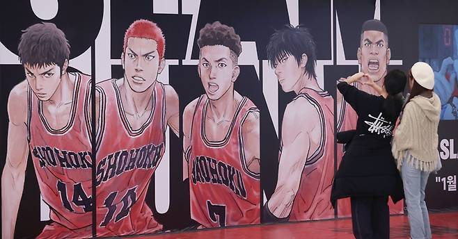 영화 "더 퍼스트 슬램덩크"가 300만 관객을 돌파한 3월16일 서울 시내 한 영화관을 찾은 시민들이 슬램덩크 홍보물 앞에서 인증 사진을 찍고 있다. ⓒ연합뉴스