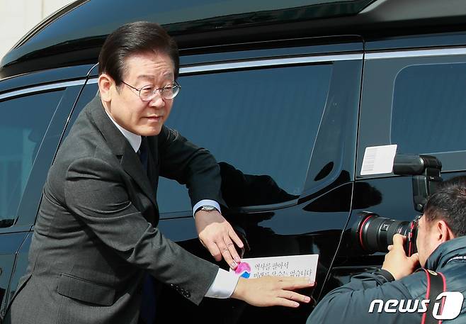 이재명 더불어민주당 대표가 22일 서울 여의도 국회에서 대일굴종외교 규탄 태극기달기 운동 행사의 일환으로 차량에 태극마크와 '역사를 팔아서 미래를 살 수는 없습니다'라고 적힌 스티커를 부착하고 있다. 2023.3.22/뉴스1 ⓒ News1 안은나 기자