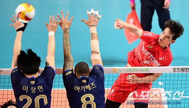 2022-2023 프로배구 V리그 준플레이오프 우리카드와 한국전력의 경기가 22일 장충체육관에서 열렸다. 한국전력 임성진이 우리카드 아가메즈의 블로킹 사이로 스파이크를 강타하고 있다.  장충=최문영 기자 deer@sportschosun.com/2023.03.22/