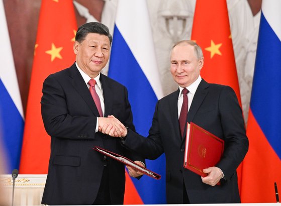 21일 시진핑(왼쪽) 중국 국가주석이 블라디미르 푸틴(오른쪽) 러시아 대통령이 공동성명에 서명 후 악수하고 있다. 신화=연합뉴스