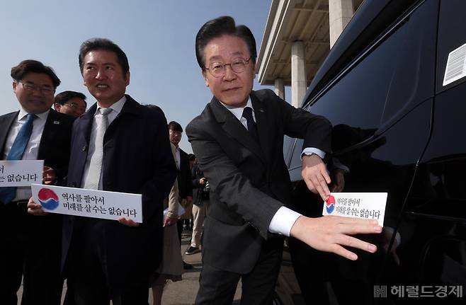 더불어민주당 대일굴종외교 규탄 태극기달기 운동 행사가 22일 서울 영등포구 여의도 국회 본청 앞에서 열려 이재명 대표가 '역사를 팔아서 미래를 살 수는 없습니다' 문구가 담긴 태극기 스티커를 차량에 붙이고 있다. 임세준 기자