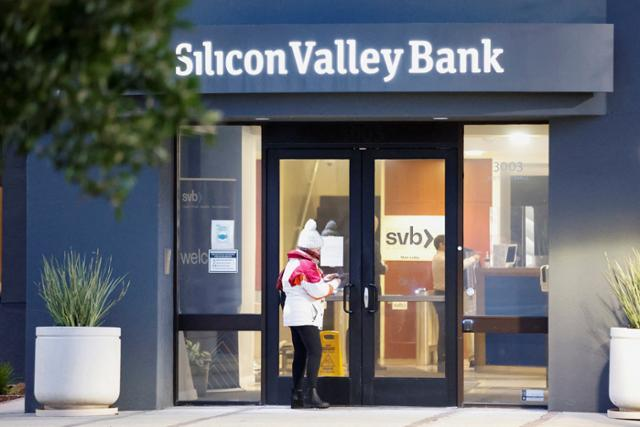 13일(현지 시간) 미 캘리포니아 산타클라라에 위치한 실리콘밸리은행(SVB) 본사 앞에서 한 고객이 유리문에 붙은 안내문을 촬영하고 있다. 로이터 연합뉴스