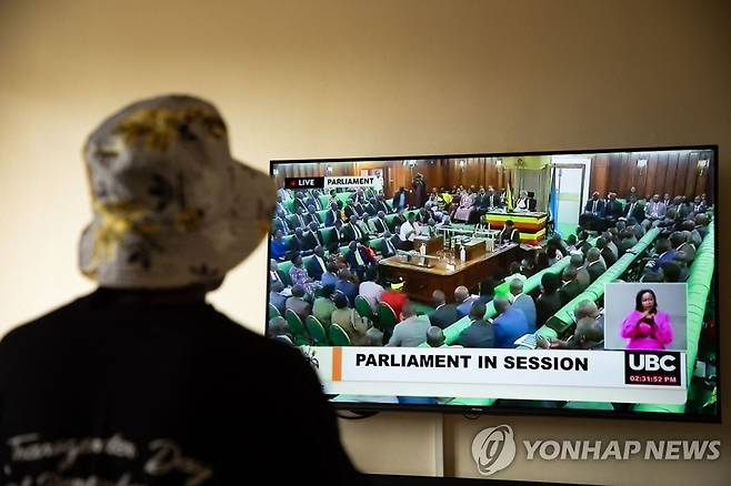 동성애자 처벌 강화 법안 논의 지켜보는 우간다 성소수자 (AFP=연합뉴스) 지난 21일(현지시간) 우간다의 트렌스젠더 여성이 의회에서 성소수자 처벌 강화법을 논의하는 모습을 TV를 통해 지켜보고 있다. 재판매 및 DB 금지