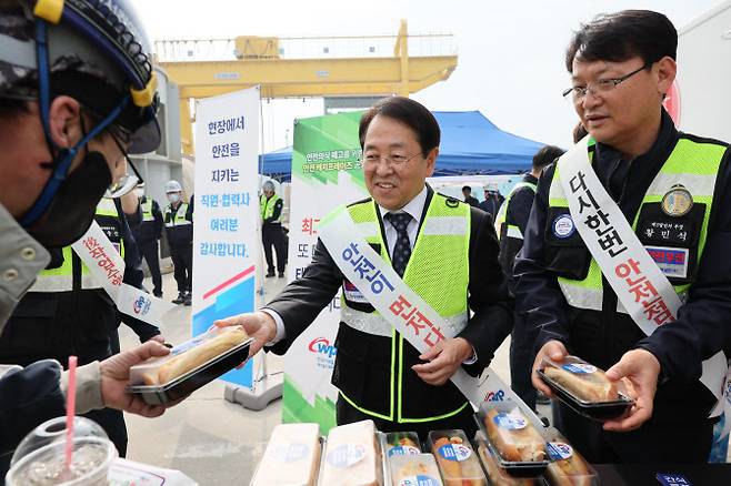 박형덕 한국서부발전 사장(가운데)이 지난 22일 태안발전본부에서 이곳 발전소 계획예방정비 공사를 진행 중인 협력사 근로자에게 ‘안전 푸드트럭’ 식사를 나눠주고 있다. (사진=서부발전)