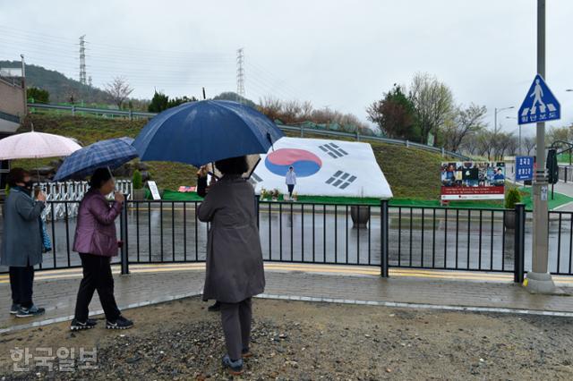 박근혜 전 대통령의 지지자들이 23일 대구 달성군 유가읍 쌍계리 박 전 대통령의 자택 앞에서 대형 태극기를 둘러보고 있다. 대구=류수현 기자