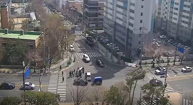 Passersby gather around a car that fell on its side at a junction in eastern Ulsan at 11:45 a.m. Tuesday. (Ulsan Metropolitan Police)