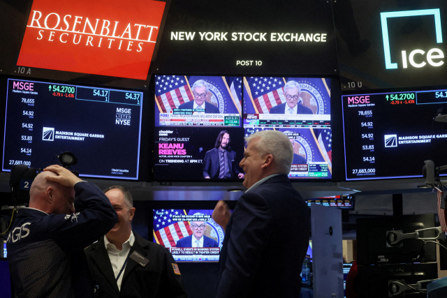 Traders react as Federal Reserve Chair Jerome Powell is seen delivering remarks on a screen, on the floor of the New York Stock Exchange (NYSE) in New York City, U.S., March 22, 2023. REUTERS/Brendan McDermid