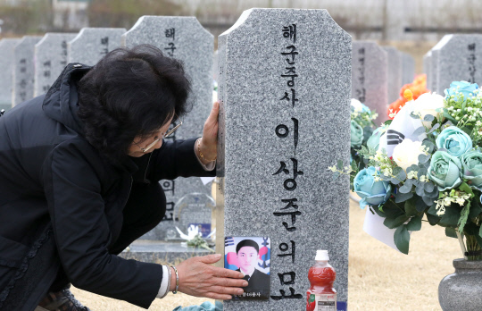 제8회 서해수호의날을 하루 앞둔 23일 대전 유성구 국립대전현충원 천안함 46용사 묘역에서 한 유족이 아들의 사진을 어루만지고 있다. 사진=최은성 기자