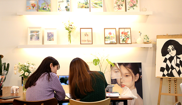 화실은 따뜻한 장소다. 아름다운 꽃그림 아래에서 송신화 원장(오른쪽)이 기자에게 그림 그리는 법을 가르쳐주고 있다.