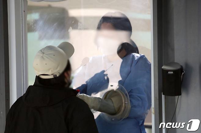 13일 오전 서울 용산구보건소 코로나19 선별진료소에서 한 시민이 검사를 받고 있다. 2023.3.13/뉴스1 ⓒ News1 이승배 기자