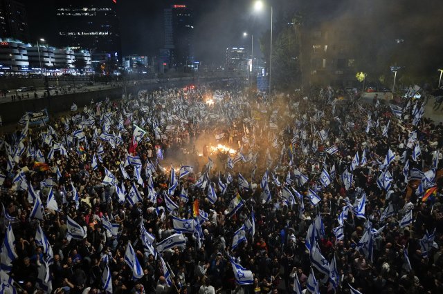 26일(현지시간) 이스라엘 텔아비브에서 사법 개혁 반대 시위대가 베냐민 네타냐후 총리의 국방장관 해임 이후 고속도로에 모닥불을 피우고 모여 시위하고 있다. 2023.03.27. [텔아비브=AP/뉴시스]