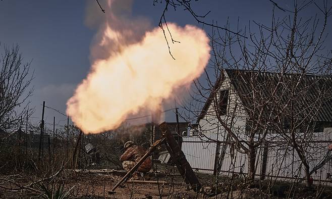 26일(현지시간) 우크라이나 도네츠크주 바흐무트 인근 전선에서 우크라이나 군인들이 러시아 진지를 향해 박격포를 쏘고 있다. AP뉴시스