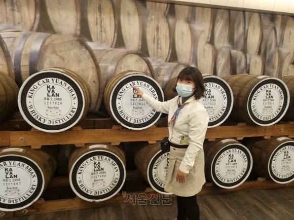 대만 킹카그룹은 오크통을 비롯한 재료를 모두 수입해 세계 최고의 위스키 카발란을 만들어 냈다. 직원 헬렌이 오크통을 가리키고 있다.