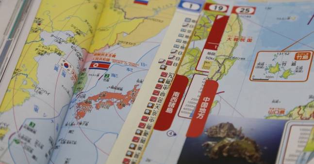 일본 문부과학성이 28일 교과서 검정심의회를 열어 2024년도부터 초등학교에서 쓰일 교과서 149종이 심사를 통과했다고 밝혔다. 사진에서 오른쪽 책은 독도에 대해 현행 "한국에 점거돼"라는 표현을 "한국에 불법으로 점거돼"로 바꾼 도쿄서적 지도 교과서. 왼쪽 책은 독도와 울릉도 사이에 국경선을 그려 독도가 일본 땅처럼 보이게 했다. 도쿄=연합뉴스