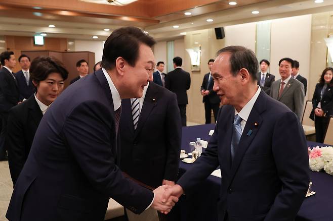 윤석열 대통령이 17일 도쿄 시내 한 호텔에서 열린 일한의원연맹 및 일한친선협회중앙회 접견에서 스가 요시히데 전 총리와 악수하고 있다. (대통령실 제공) 2023.3.19/뉴스1 ⓒ News1 안은나 기자