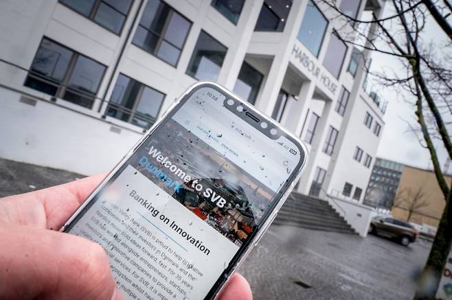 지난 13일(현지시간) 덴마크 코펜하겐에서 한 네티즌이 스마트폰으로 실리콘밸리은행(SVB) 홈페이지를 접속하고 있다.로이터뉴스1