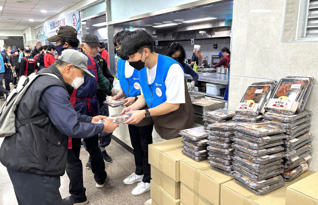 GS25 임직원들이 29일 성남시 ‘안나의 집’에서 노숙인들에게 김혜자 도시락을 전달하고 있다. /사진 제공=GS25