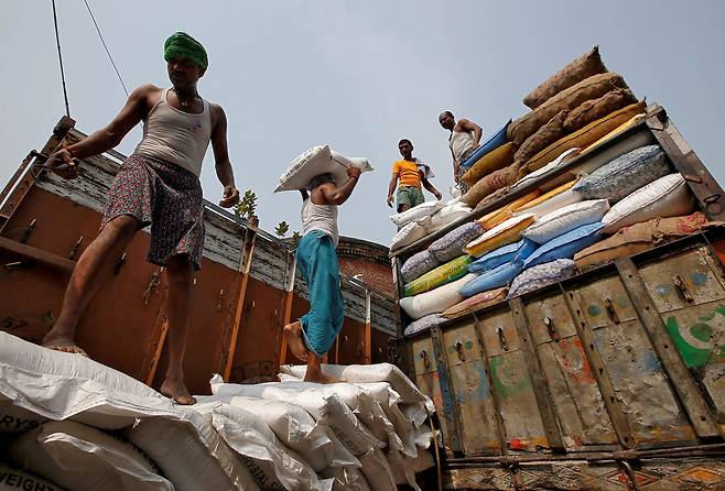 인도 콜카타의 도매 시장에서 설탕 자루를 나르고 있는 노동자들. / 로이터