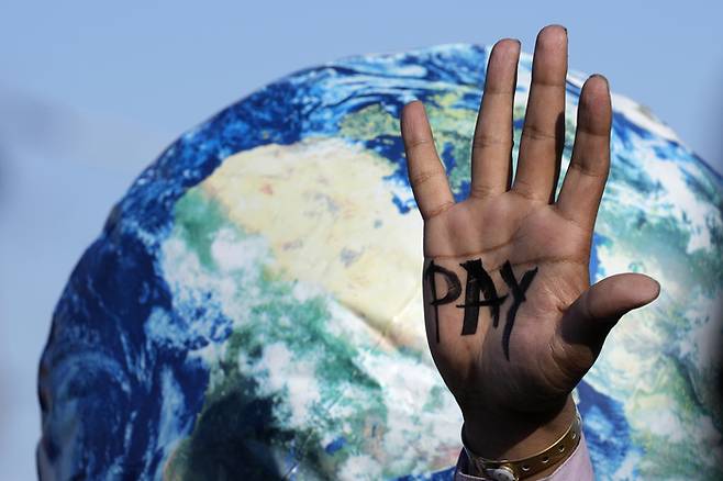 환경운동가들이 기후위기를 촉발한 선진국들이 손실을 본 개발도상국에 보상할 것을 촉구하며 ‘지불’이라는 글자가 쓰인 손바닥을 펼쳐 보이고 있다. 샤름엘셰이크 | AP연합뉴스