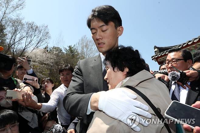전직 대통령 고(故) 전두환 씨의 손자 전우원 씨가 31일 오전 광주 북구 운정동 국립 5·18민주묘지에서 5·18 유가족인 김길자 씨를 위로하고 있다.[연합]