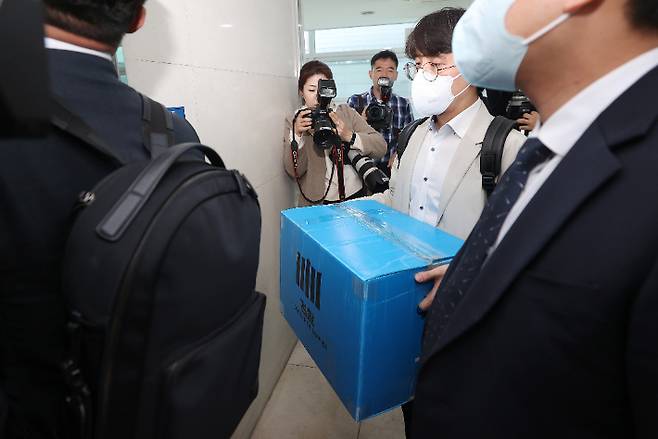 양재식 변호사 사무실 압수수색 마친 검찰     (서울=연합뉴스) 신현우 기자 = 검찰이 박영수 전 국정농단 사건 특별검사에 대해 강제수사에 나서며 이른바 '대장동 50억 클럽' 수사를 본격화한 30일 오후 서울 서초구 양재식 변호사 사무실에서 압수수색을 마친 검찰 관계자들이 압수품을 옮기고 있다.     박 전 특검은 우리은행 이사회 의장으로 재직하던 2014년 화천대유자산관리 대주주 김만배 씨 등이 대장동 개발사업 공모를 준비할 때 부국증권 배제 등 컨소시엄 구성을 돕고 프로젝트파이낸싱(PF) 대출을 청탁하는 대가로 50억원을 받기로 한 혐의를 받는다. 양 변호사는 이 과정에서 민간업자와 실무 업무를 담당한 것으로 조사됐다. 2023.3.30     nowwego@yna.co.kr (끝)   연합뉴스